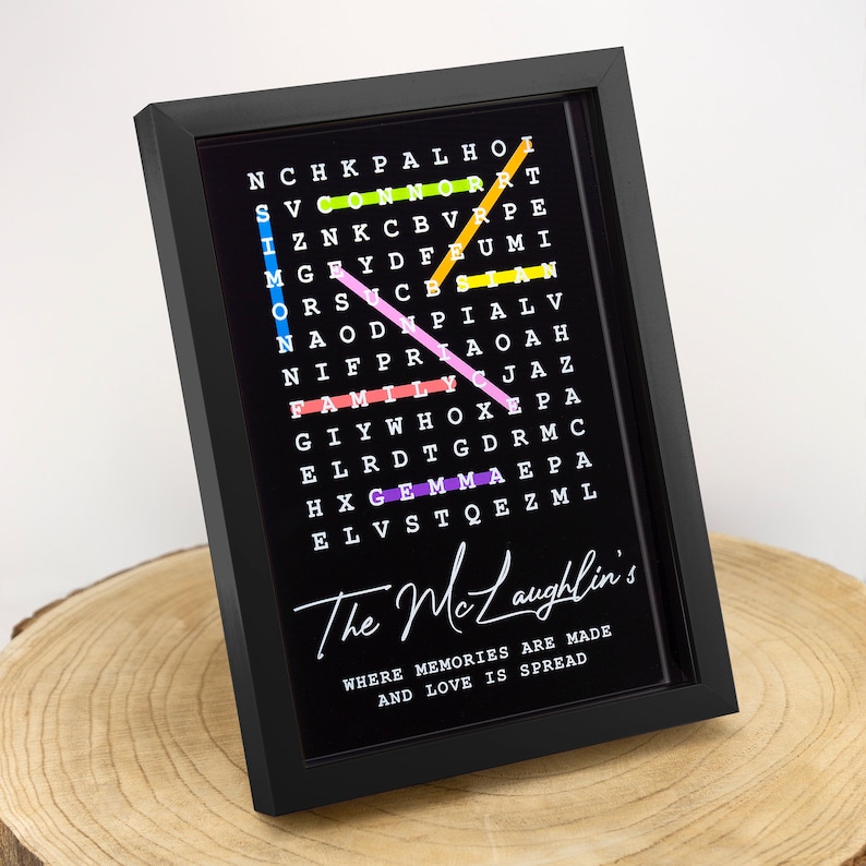 May include: A black framed word search puzzle with colorful letters spelling out the words "family", "love", "memories", and "gem". The text below the puzzle reads "The McLaughlin's Where memories are made and love is spread".