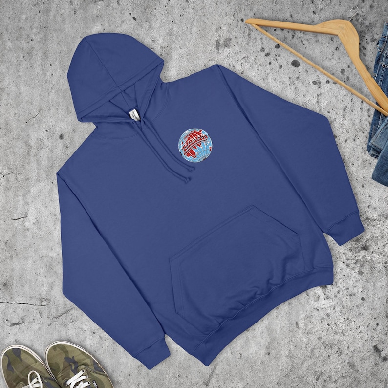 May include: A navy blue hoodie with a front pocket and a drawstring hood. The sweatshirt features a small embroidered globe design with red and blue accents on the upper left chest. The garment is made of a soft material.