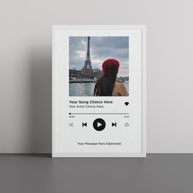 May include: A digital music player mockup with a photo of the Eiffel Tower in Paris, France. The text "Your Song Choice Here" and "Your Artist Choice Here" is displayed on the screen. The play button is highlighted.