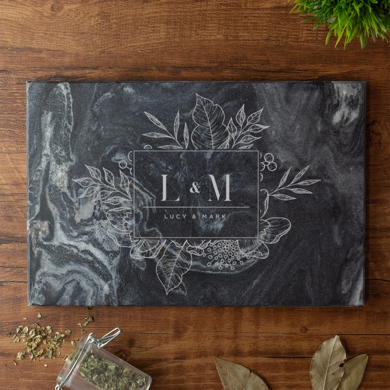 May include: Black marble cutting board with a white floral design and the initials "L & M" with the text "Lucy & Mark" below.