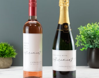 Puede incluir: Dos botellas de vino con etiquetas personalizadas. La etiqueta de la botella de la izquierda dice "Combina bien con la jubilación. Felicitaciones, te echaremos de menos". La etiqueta de la botella de la derecha dice "Combina bien con la jubilación. Felicitaciones, te echaremos de menos".