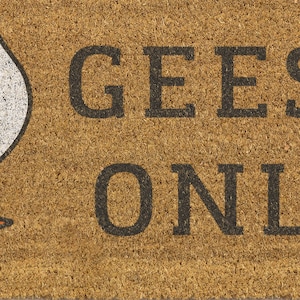 May include: A rectangular doormat made of natural coir fiber. The mat features the words "GEESE ONLY" in bold, black capital letters. A white goose graphic is visible on the left side of the mat.