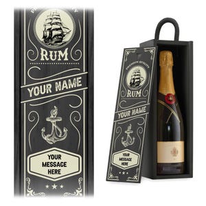 May include: A black wooden wine box with a handle, featuring a sliding lid printed with a sailing ship, an anchor, and the text "PREMIUM QUALITY RUM," "YOUR NAME," and "YOUR MESSAGE HERE." A bottle of sparkling wine is inside the box.