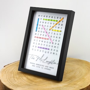 May include: A black framed word art piece with a white background. The word art features a colorful word search puzzle with the words "The McLaughlin's" written below. The text below the word search reads "Where memories are made and love is spread."