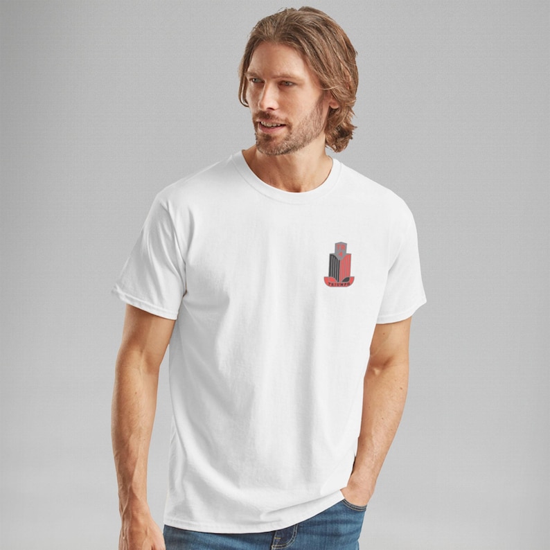 K&ouml;nnte beinhalten: Wei&szlig;es T-Shirt mit einem kleinen, stilisierten Geb&auml;ude-Grafik in Rot, Schwarz und Grau auf der linken Brust. Das Wort "FAIRWAY" steht darunter. Das T-Shirt hat kurze &Auml;rmel.
