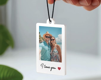 Könnte beinhalten: Ein weißes, rechteckiges Foto-Ornament mit schwarzem Band. Das Ornament zeigt ein Farbfoto eines Paares am Strand. Die Worte "I love you" und ein rotes Herz sind darunter gedruckt.