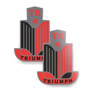 Könnte beinhalten: Zwei Triumph TR4 Emblem-Aufkleber. Jedes Emblem hat einen grauen oberen Bereich mit "TR 4" in Rot, eine schwarz-rot gestreifte Mitte und eine rote Basis mit "TRIUMPH" in Weiß. Die Aufkleber befinden sich auf weißem Hintergrund.
