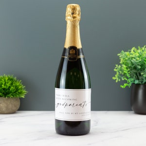 May include: A bottle of champagne with a white label that says "Pairs well with becoming godparents. Will you be my godparents? Love [Name]"
