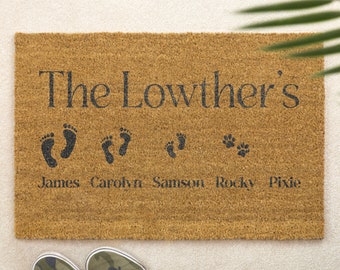 May include: A brown coir doormat with the text "The Lowthers" and footprints for James, Carolyn, Samson, and paw prints for Rocky and Pixie.