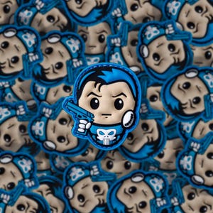 May include: A collection of blue and tan patches featuring a cartoon character holding a blue gun. The character has a skull emblem on the chest and blue hair. The patches are likely for clothing or accessories.