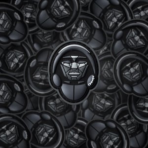 May include: A close-up of a black and gray geometric design patch with the word "Crones" printed on it. The patch features a stylized face with headphones and is surrounded by other similar patches.