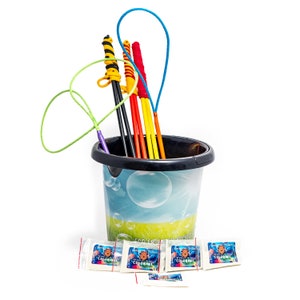 Peut inclure: Un seau noir rempli de baguettes à bulles colorées et de sachets de solution à bulles. Les baguettes sont de différentes couleurs, dont le jaune, le rouge et le noir. Le seau présente un motif de bulles et l'inscription "Eco Friendly".