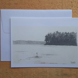 May include: A pencil sketch of a serene lake scene with a small island of trees on the right and a distant mountain range. A small flag is in the water. The artwork is on a white card with a matching envelope.