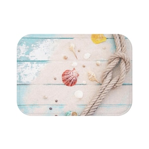 May include: A light blue and white wooden background with a rope tied in a knot. The background is covered in sand and seashells. The rope is made of natural fiber and is a light brown color.