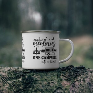 May include: White enamel camping mug with black text and a silhouette of a camper. The text reads "making memories one campsite at a time".