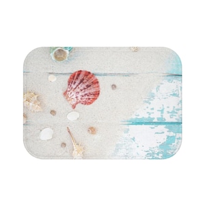 May include: A light blue and white wooden background with a red seashell and other seashells in various colors and sizes.