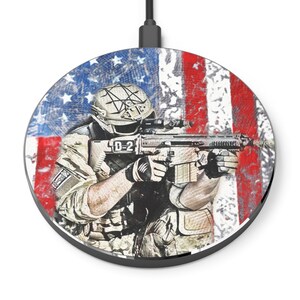 May include: A round wireless charging pad with a graphic of a soldier holding a rifle in front of an American flag. The flag is red, white, and blue with a distressed look. The soldier is wearing a helmet and camouflage clothing. The charging pad is black with a USB-C port.