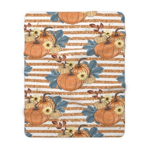 May include: A white and gold striped background with a repeating pattern of orange pumpkins, blue leaves, and yellow flowers. The pumpkins are arranged in groups of three, with the largest pumpkin in the center.