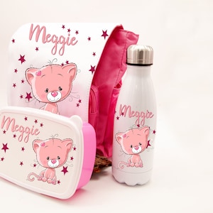 Può includere: Zaino, lunchbox e borraccia rosa con un designo di gatto rosa e il nome "Meggie" su ciascuno. Il gatto ha un cuore rosa sul petto ed è circondato da stelle rosa.