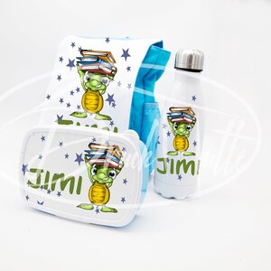 Può includere: Una borsa da pranzo blu con una tartaruga che trasporta libri e il nome "Jimi" stampato su di essa. Sono inclusi anche una scatola da pranzo e una borraccia abbinate con lo stesso design.