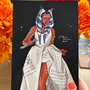 May include: A print featuring a stylized illustration of a character with blue and white head tails, wearing a white dress with text. The character is holding a lightsaber against a black background. The artist's signature is in the lower right corner.