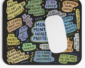 May include: A black mouse pad with colorful text and illustrations. The text includes phrases like "My worth is not measured by my success", "I learn from my mistakes", "Mental health matters", "I am allowed to feel my emotions", and "It's okay to make mistakes".