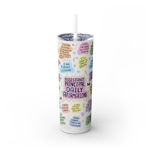 May include: A white tumbler with a straw, featuring colorful text and illustrations. The tumbler is decorated with affirmations for an assistant principal, including phrases like "I am a great listener" and "Every storm makes me stronger."