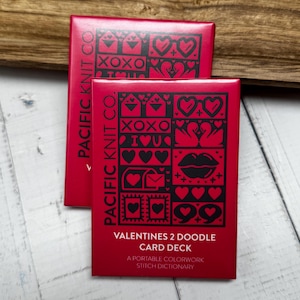 May include: Two red boxes with black text and illustrations. The top box says "Pacific Knit Co." and the bottom box says "Pacific Knit Co." and "Valentines 2 Doodle Card Deck. A Portable Colorwork Stitch Dictionary."