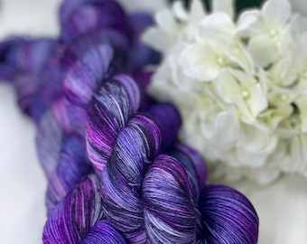 Può includere: Gomitoli di filato di colore viola, nero e bianco con un motivo di colore variegato. Il filato è morbido e soffice, perfetto per lavorare a maglia o all'uncinetto.