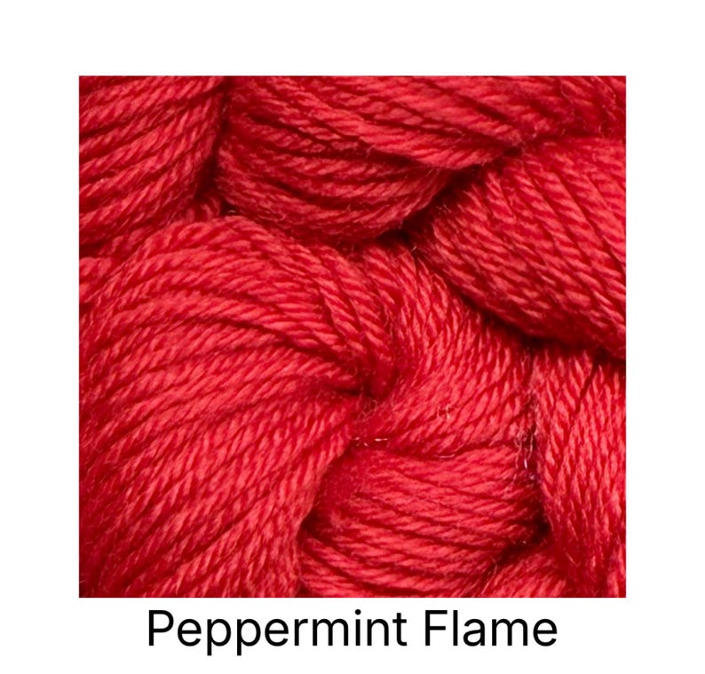 K&ouml;nnte beinhalten: Nahaufnahme eines leuchtend roten Garns, das eng zu einem Kn&auml;uel gewickelt ist. Das Garn hat ein strukturiertes Aussehen mit sichtbaren Str&auml;ngen. Der Text "Peppermint Flame" wird darunter angezeigt. Dieses Garn eignet sich f&uuml;r Strick- und H&auml;kelprojekte.