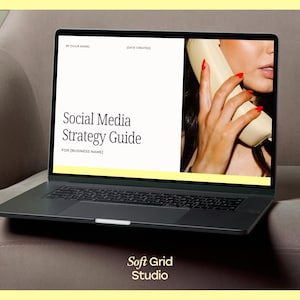 May include: A laptop computer displaying a social media strategy guide with the text "Social Media Strategy Guide" and "FOR [BUSINESS NAME]" on a white background. The right side of the screen shows a woman holding a vintage phone with red nail polish.