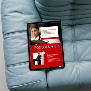 Pu&ograve; includere: Un tablet nero che mostra una pagina web rossa e bianca con il testo "FREE BONUSES". Il tablet &egrave; appoggiato su un divano in pelle trapuntata blu chiaro. La pagina web include immagini di una donna e un uomo.