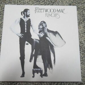 Puede incluir: Una portada de &aacute;lbum en blanco y negro con dos personas, un hombre y una mujer, de pie en un escenario. La portada del &aacute;lbum es para el &aacute;lbum "Rumours" de Fleetwood Mac.