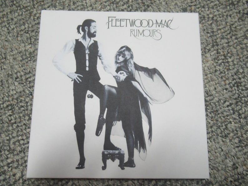 Puede incluir: Una portada de &aacute;lbum en blanco y negro con dos personas, un hombre y una mujer, de pie en un escenario. La portada del &aacute;lbum es para el &aacute;lbum "Rumours" de Fleetwood Mac.