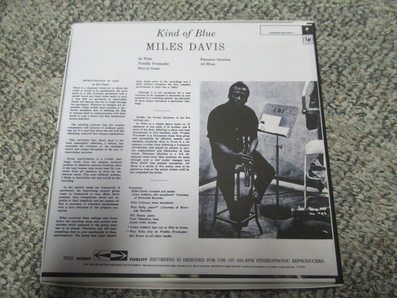 K&ouml;nnte beinhalten: Ein Schwarzwei&szlig;foto eines Mannes, der Trompete spielt. Das Foto stammt von der R&uuml;ckseite einer Schallplatte mit dem Titel "Kind of Blue" von Miles Davis. Der Text "CRI" ist auf einem Notenst&auml;nder im Hintergrund zu sehen.
