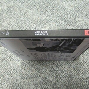 K&ouml;nnte beinhalten: Schwarze Box mit dem Text "MILES DAVIS KIND OF BLUE" auf dem R&uuml;cken. Die Nummer "2" befindet sich auf der linken Seite des R&uuml;ckens. Die Box steht auf einem grauen Teppich.
