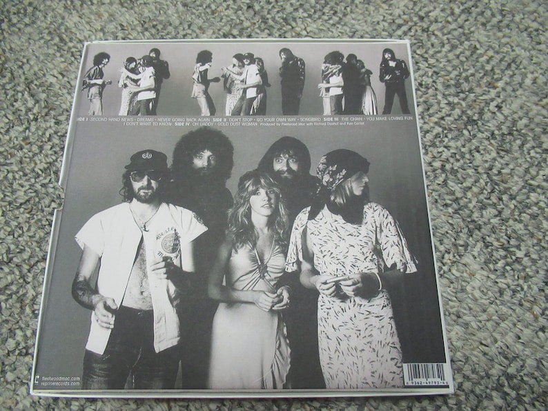 Puede incluir: Portada de &aacute;lbum de fotos en blanco y negro con una banda de siete personas. La portada del &aacute;lbum tiene el nombre de la banda "Fleetwood Mac" impreso en letras blancas en la parte superior. El t&iacute;tulo del &aacute;lbum "Rumours" est&aacute; impreso en letras blancas debajo del nombre de la banda. La portada del &aacute;lbum presenta una foto de los miembros de la banda de pie en fila. Los miembros de la banda visten ropa informal. La portada del &aacute;lbum es un ejemplo cl&aacute;sico del arte de las portadas de &aacute;lbumes de la d&eacute;cada de 1970.
