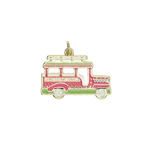 May include: A gold-toned metal charm shaped like a jeepney, featuring vibrant pink, green, and white enamel detailing. The design includes a roof rack, side panels with intricate patterns, and a small circular jump ring at the top for attachment.