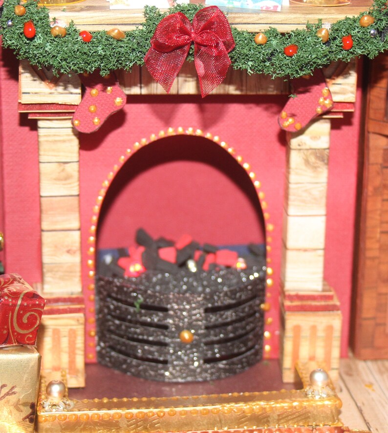 May include: A miniature fireplace with a red brick facade, a green garland with red berries and a red bow, and a black metal fire grate with glowing embers.