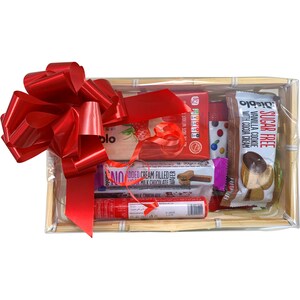 May include: A gift basket filled with various chocolate and cookie snacks. The basket is wrapped in clear cellophane and tied with a red bow. The snacks include a sugar-free vanilla cookie with cocoa cream, a chocolate wafer, and a milk chocolate bar.