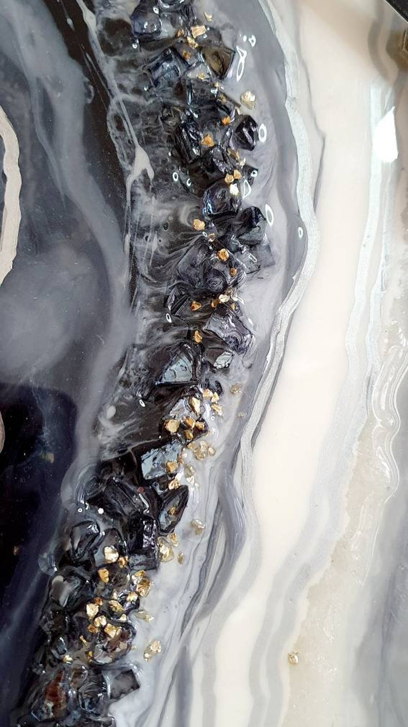 May include: Abstract art painting with black, white, and gold accents. The painting features a swirling, marbled design with embedded black and gold glitter.