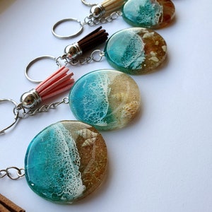 Ronde sleutelhanger met natuurlijke schelpen/sterren van epoxyhars, met kwastje. Sleutelhanger met amber en zeegolven. Verjaardagscadeau Cadeau zeeliefhebber