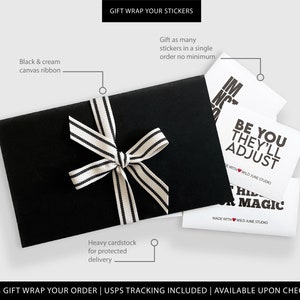 May include: A black gift box with a black and white striped ribbon. The box is filled with white cards with black text. The text on the cards reads "Be You They'll Adjust" and "Let Your Magic Shine".