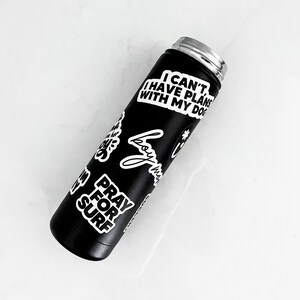 A black insulated water bottle with various stickers on it, including one that says "I CAN'T I HAVE PLAN WITH MY DOG".