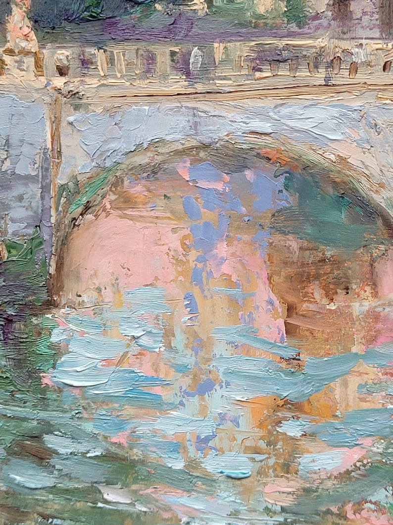 May include: Impressionistic oil painting of a bridge over water. The bridge is painted in shades of gray and beige, with a pink and blue arch. The water is depicted with blue and green brushstrokes, creating a textured effect.