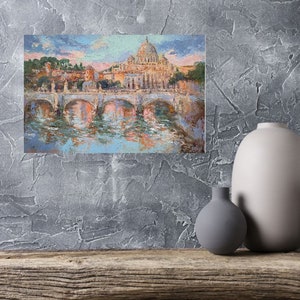 May include: An impressionistic painting of a European cityscape featuring a domed cathedral, arched bridges, and a river. The artwork uses a palette of blues, oranges, and pinks, with visible brushstrokes. The painting is displayed on a textured gray wall.