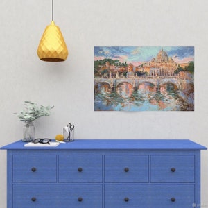 May include: An oil painting depicting a cityscape with a bridge and a large domed building, likely a cathedral. The artwork is displayed on a wall above a blue dresser. The painting's colors include blues, oranges, and greens, reflecting in the water.