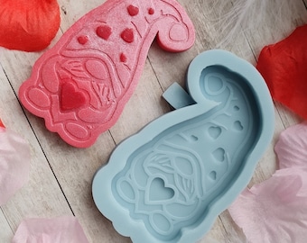Könnte beinhalten: Eine blaue Silikonform zum Herstellen eines gnomförmigen Harzschmucks. Die Form hat ein detailliertes Design mit Herzen und einem Bart.