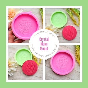 May include: Two pink silicone molds for making resin crafts. The molds are round and feature a design of a crystal moon with flowers and stars. The text "Silicone Moulds Crystal Moon Mould www.themouldking.co.uk" is printed on a white circle.