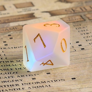 May include: A large, frosted white, twenty-sided die with gold-colored numerals. The die is illuminated with a soft, colorful glow. The background is a vintage-style paper with text related to role-playing games.